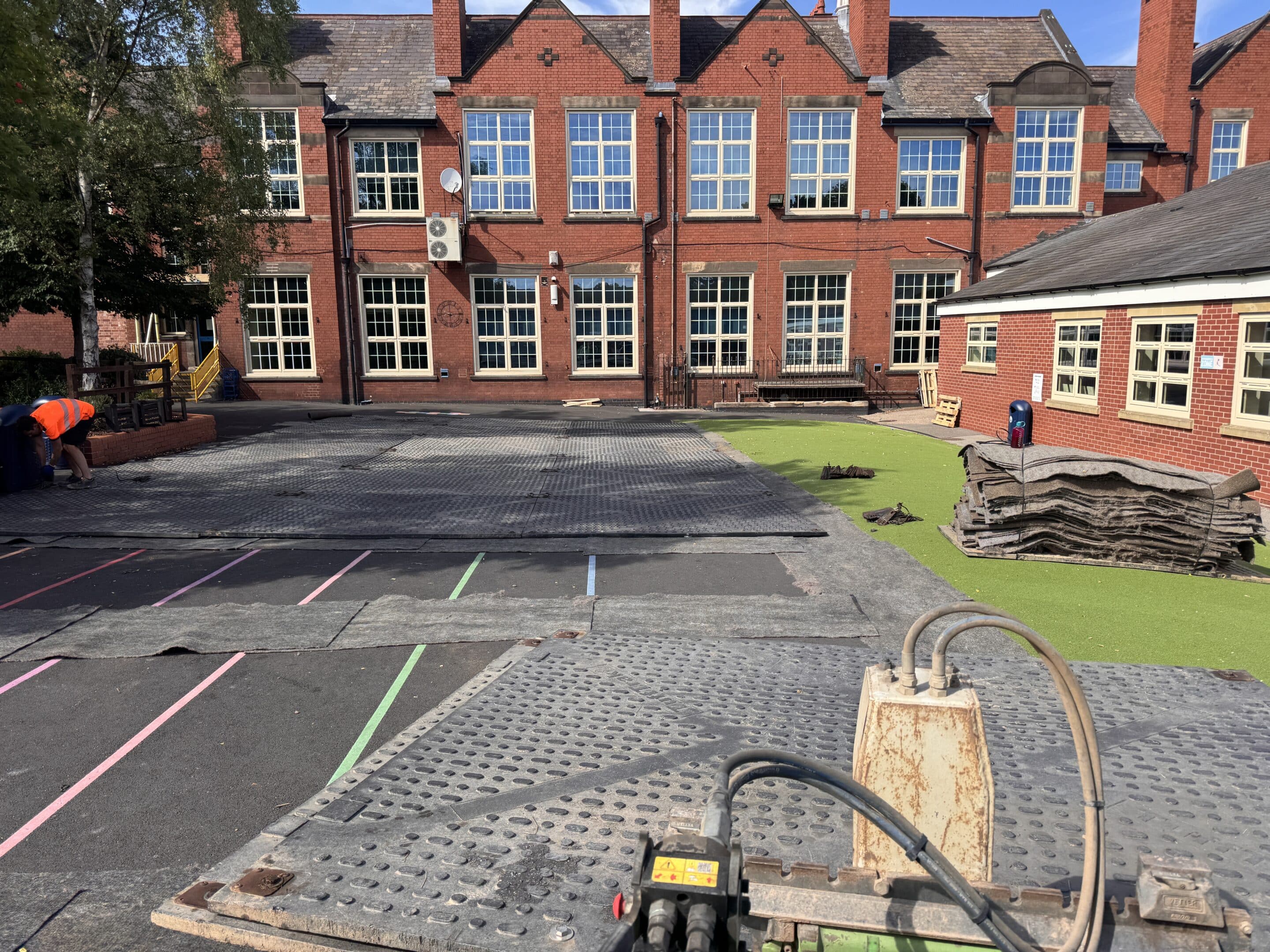 Ground protection mats being installed in the playground area at Dale Community School Derby